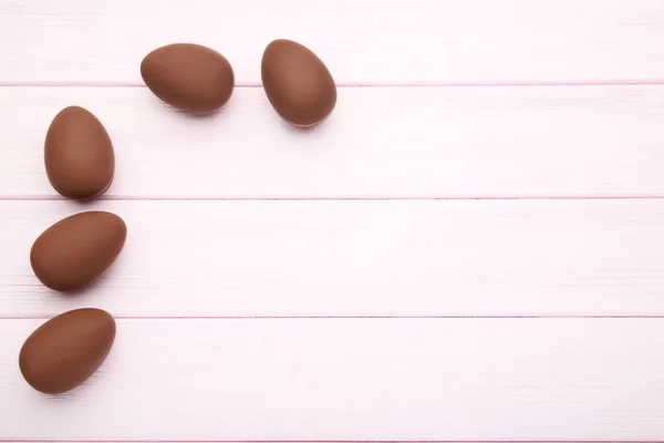 Chocolate easter eggs on pink wooden table — Stock Photo, Image