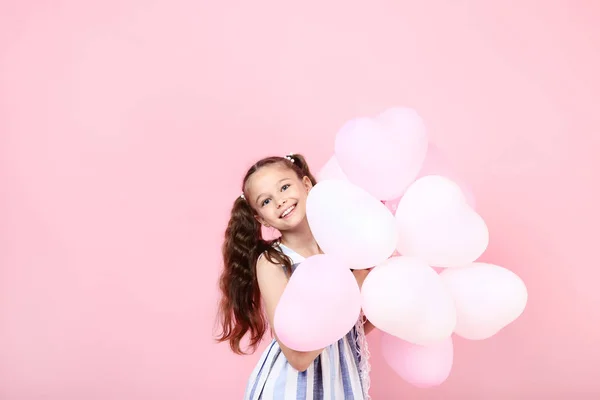 Menina com balões no fundo rosa — Fotografia de Stock