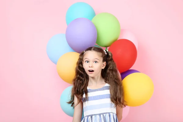 Menina com balões coloridos no fundo rosa — Fotografia de Stock