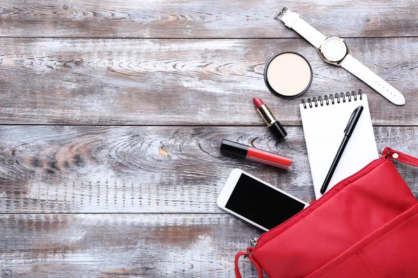 Kozmetik, defter, kol saati ve smartphone ile çanta 