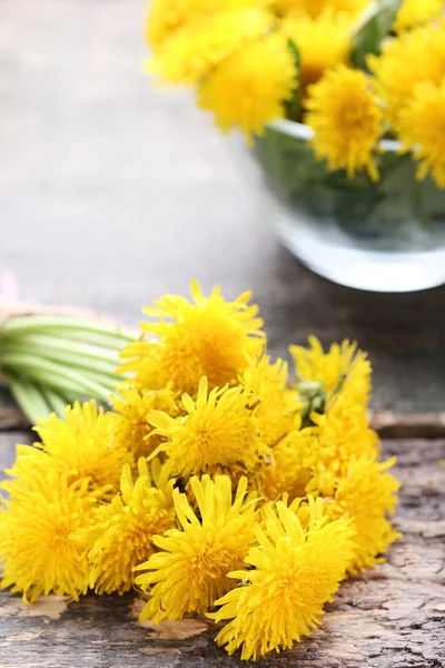 Yellow dandelions on wooden table — Stock Photo, Image