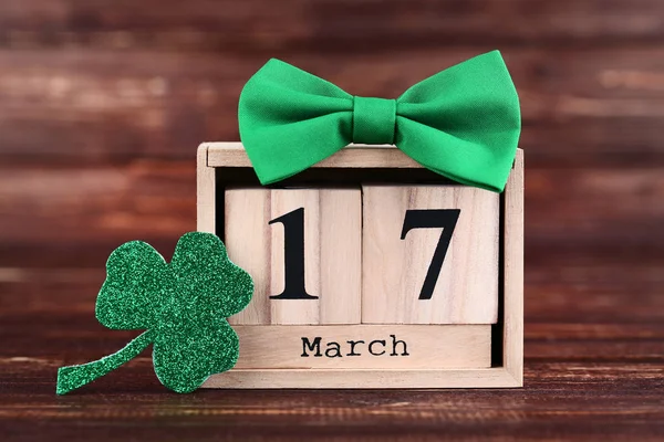 Clover leaf with wooden calendar and green bow tie — Stock Photo, Image