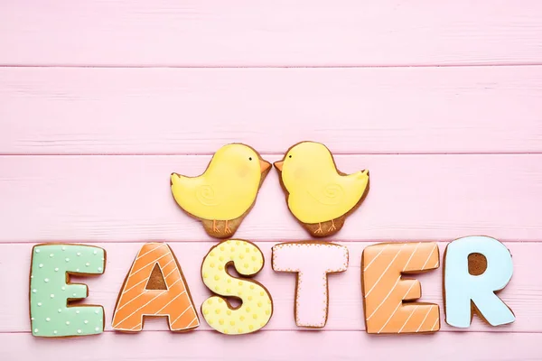 Palabra de Pascua por galletas de jengibre en la mesa de madera rosa — Foto de Stock