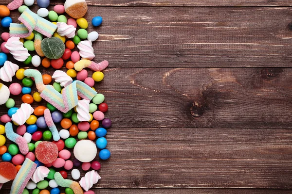 Doces doces coloridos na mesa de madeira marrom — Fotografia de Stock