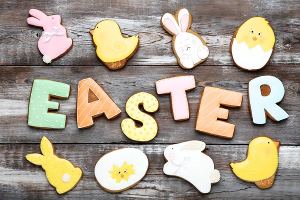 Word Easter by gingerbread cookies on brown wooden table — Stock Photo, Image