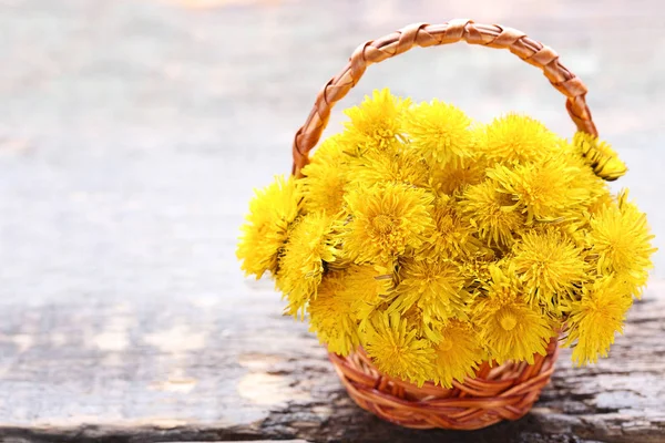 Yellow dandelions on wooden table — Stock Photo, Image