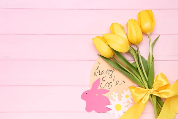 Tulipanes amarillos con conejo de papel y texto Feliz Pascua en rosa wo — Foto de Stock