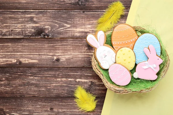 Easter gingerbread cookies in basket with yellow feathers on woo — Stock Photo, Image