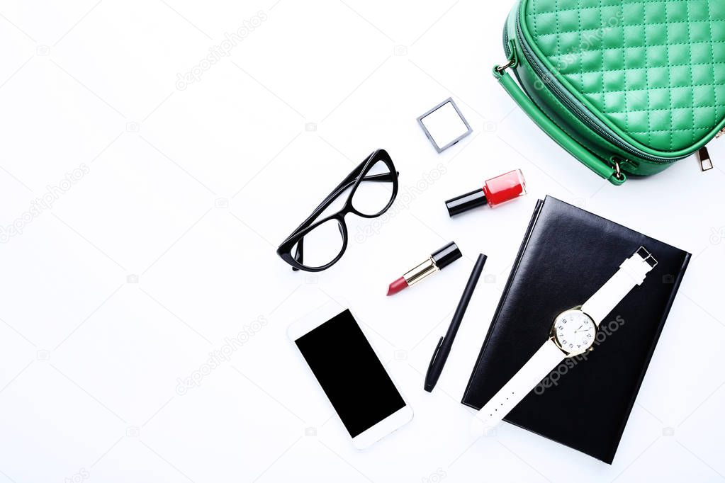 Handbag with cosmetics, smartphone, glasses and wrist watch on w