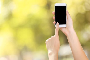 Holding ve smartphone üzerinde arka plan bulanık kullanarak kadın