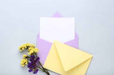 Gri arka planda çiçekler ile renkli zarflar