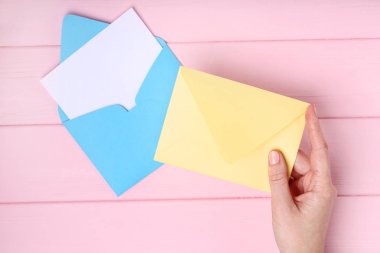 Pembe ahşap masa zarflara kağıt ile el