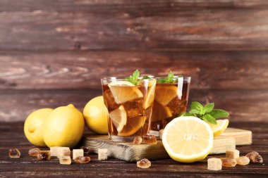 Ahşap masanın üzerine limon ve nane bardaklarda buzlu çay yapraklar