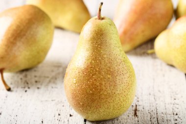 Beyaz ahşap masada su damlaları ile olgun armut