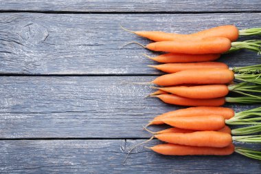 Gri ahşap masada taze havuç