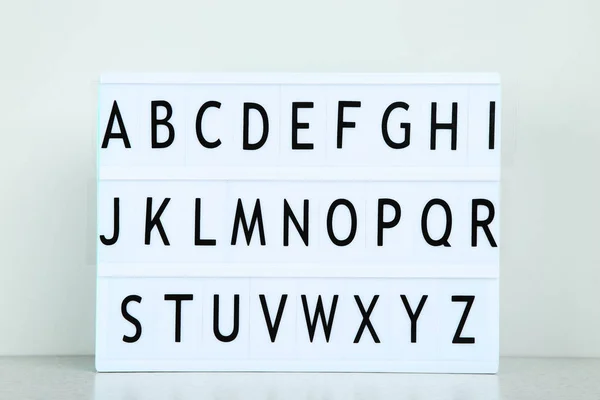 Leuchtkasten mit Buchstaben auf grauem Hintergrund — Stockfoto