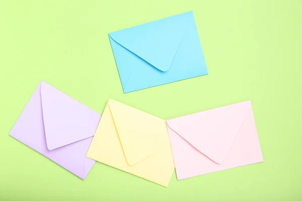 Envelopes de papel coloridos sobre fundo verde — Fotografia de Stock
