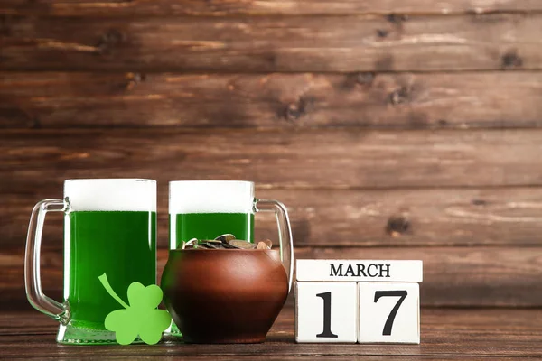 Il giorno di San Patrizio. Birra verde in tazze con calendario a cubetti e pentola — Foto Stock