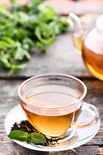 Taza de té con hojas de menta sobre mesa de madera gris — Foto de Stock