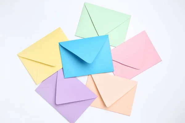 Цветные бумажные конверты на белом фоне — стоковое фото