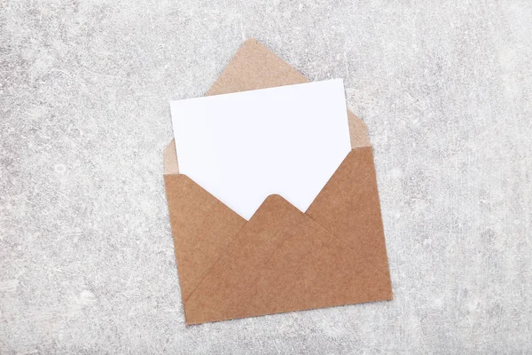Чистая бумага с конвертом на сером фоне — стоковое фото