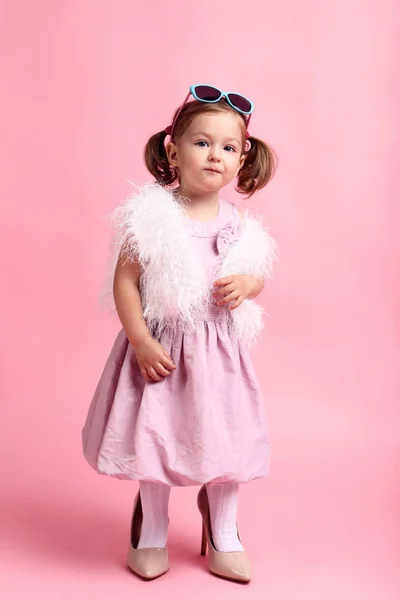 Piękna mała dziewczynka w ubrania moda na różowym tle — Zdjęcie stockowe