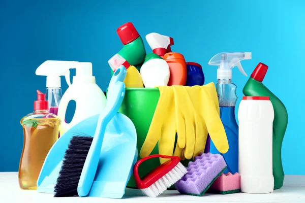 Bottles with detergent and cleaning tools on blue background — Stock Photo, Image