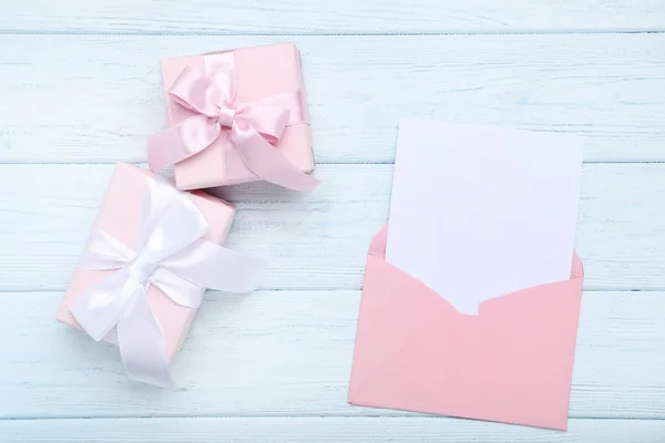 Envelope de papel com caixas de presente na mesa de madeira — Fotografia de Stock