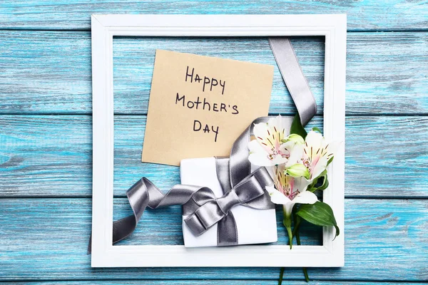 Texte Happy Mothers Day avec des fleurs et boîte cadeau sur table en bois — Photo