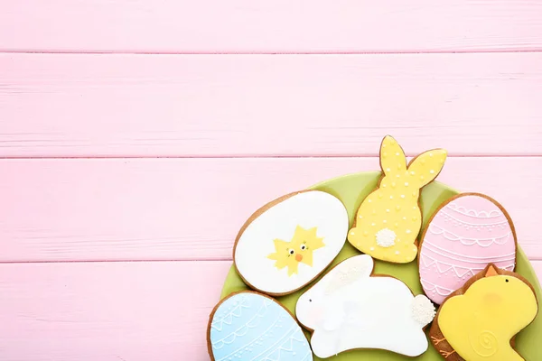 Biscoitos de gengibre de Páscoa em placa na mesa de madeira rosa — Fotografia de Stock