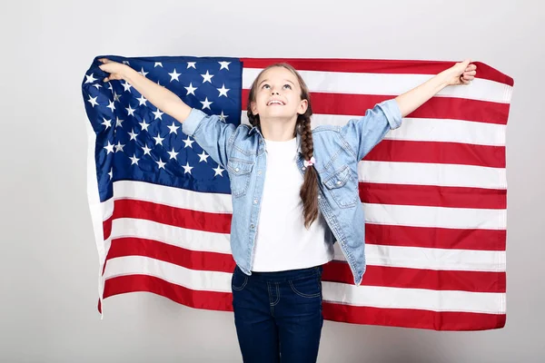 Jong meisje met een Amerikaanse vlag op de grijze achtergrond — Stockfoto