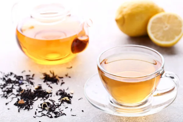 Xícara de chá com folhas secas e bule — Fotografia de Stock
