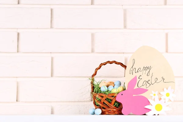 Huevos coloridos con conejo de papel y texto Feliz Pascua en ladrillo w — Foto de Stock