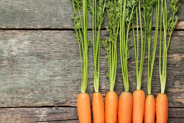 Fresh carrot on grey wooden table — Stock Photo, Image