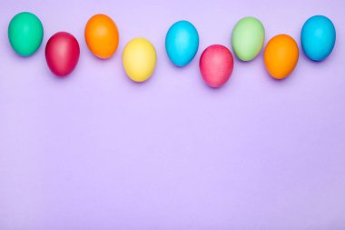 Mor arka plan üzerinde renkli Paskalya yumurtaları