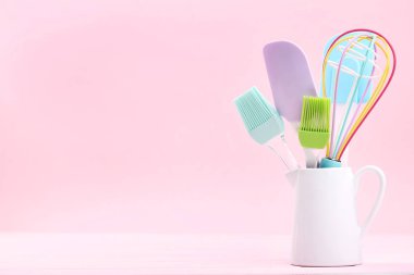 Pembe bir arka plan üzerinde beyaz kavanoz mutfak gereçleri