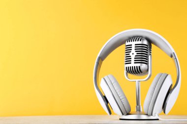 Sarı arka planda kulaklıklar ile Vintage mikrofon