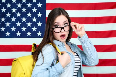 Amerikan bayrağı arka plan üzerinde sırt çantası ile genç öğrenci