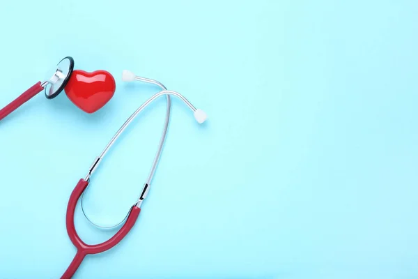 Estetoscopio con corazón rojo sobre fondo azul — Foto de Stock