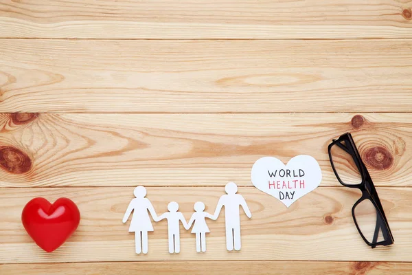 Texto Día Mundial de la Salud con figura familiar, gafas y corazón rojo — Foto de Stock