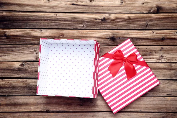 Caja de regalo roja abierta sobre mesa de madera marrón — Foto de Stock