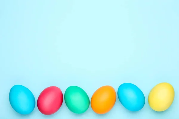 Mavi arka planda renkli paskalya yumurtaları — Stok fotoğraf