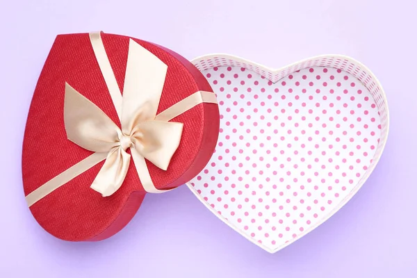 Caja de regalo en forma de corazón abierto sobre fondo púrpura — Foto de Stock
