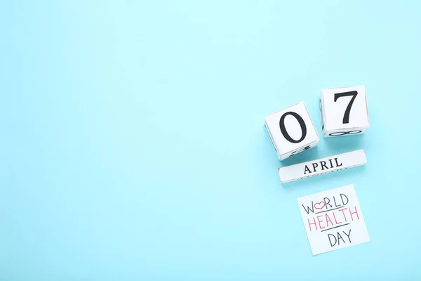 Text World Health Day with cube calendar on blue background