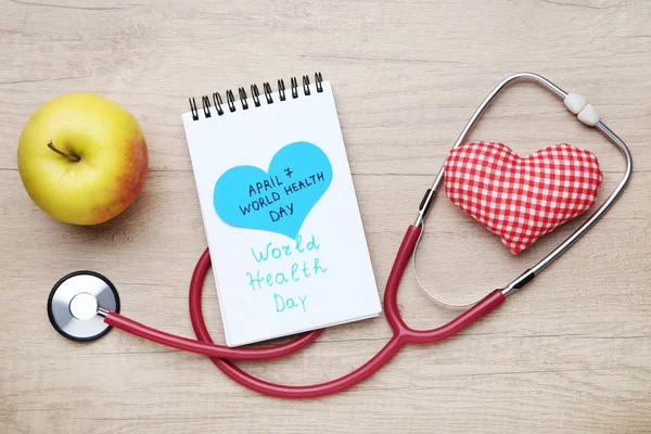 Metin Dünya Sağlık günü stetoskop ile kumaş kalp ve elma o — Stok fotoğraf