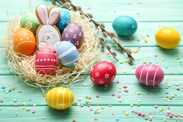Színes húsvéti tojás, mézeskalács cookie-k és a fűzfa ág — Stock Fotó