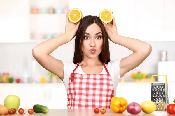 Wanita cantik memegang irisan buah jeruk dan memasak makanan di — Stok Foto