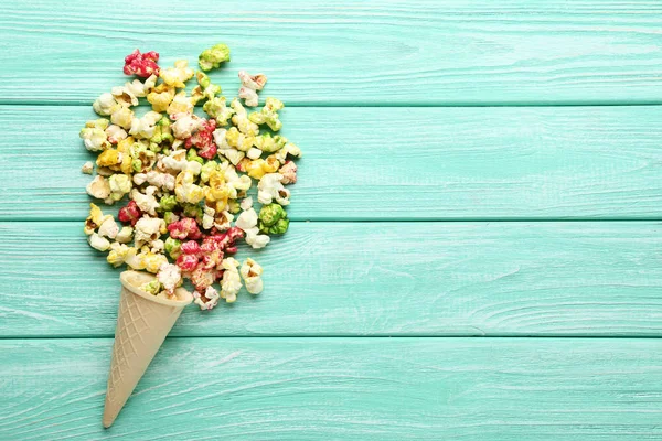 Popcorn coloré en cône de gaufre sur table en bois — Photo