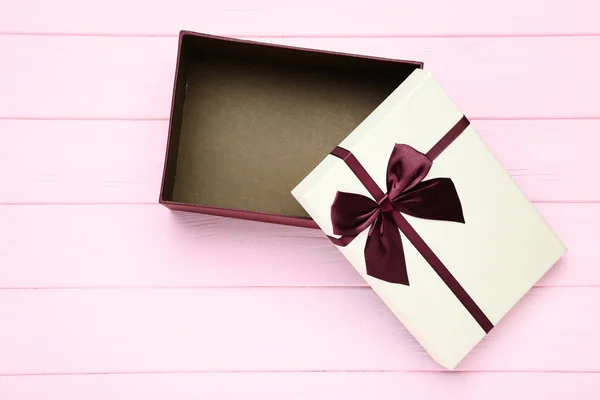 Open gift box on pink wooden table — Stock Photo, Image