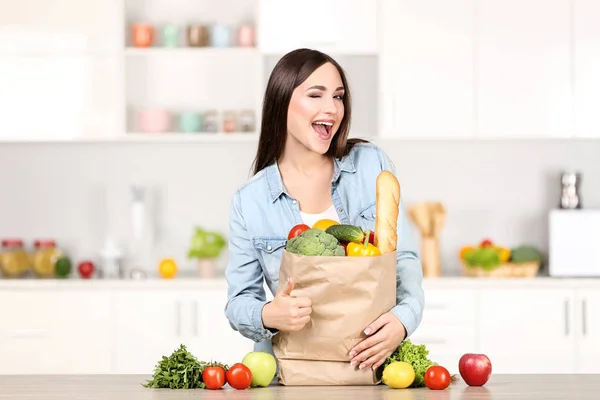 Wanita cantik berdiri di dapur dengan toko-toko ba — Stok Foto